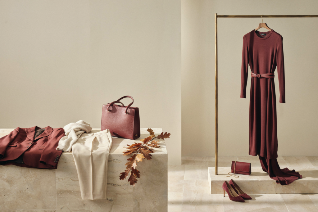 Outfit total bordeaux con blazer, borsa e pantaloni crema, e abito bordeaux appeso con scarpe e pochette coordinate: abbinamento bordeaux e crema
